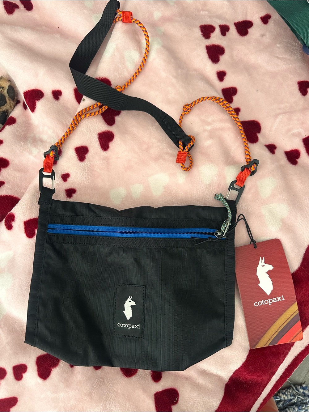 cotopaxi Black Messenger Bag with Blue Zip and Orange Strap Accents